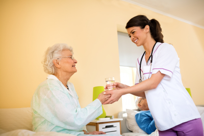 nurse giving a medicine to the senior woman