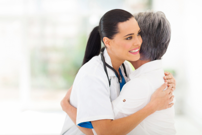 caring young medical doctor hugging senior patient