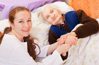 Young nurse holds the senior woman's hands
