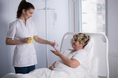 nurse giving a medicine to the senior woman